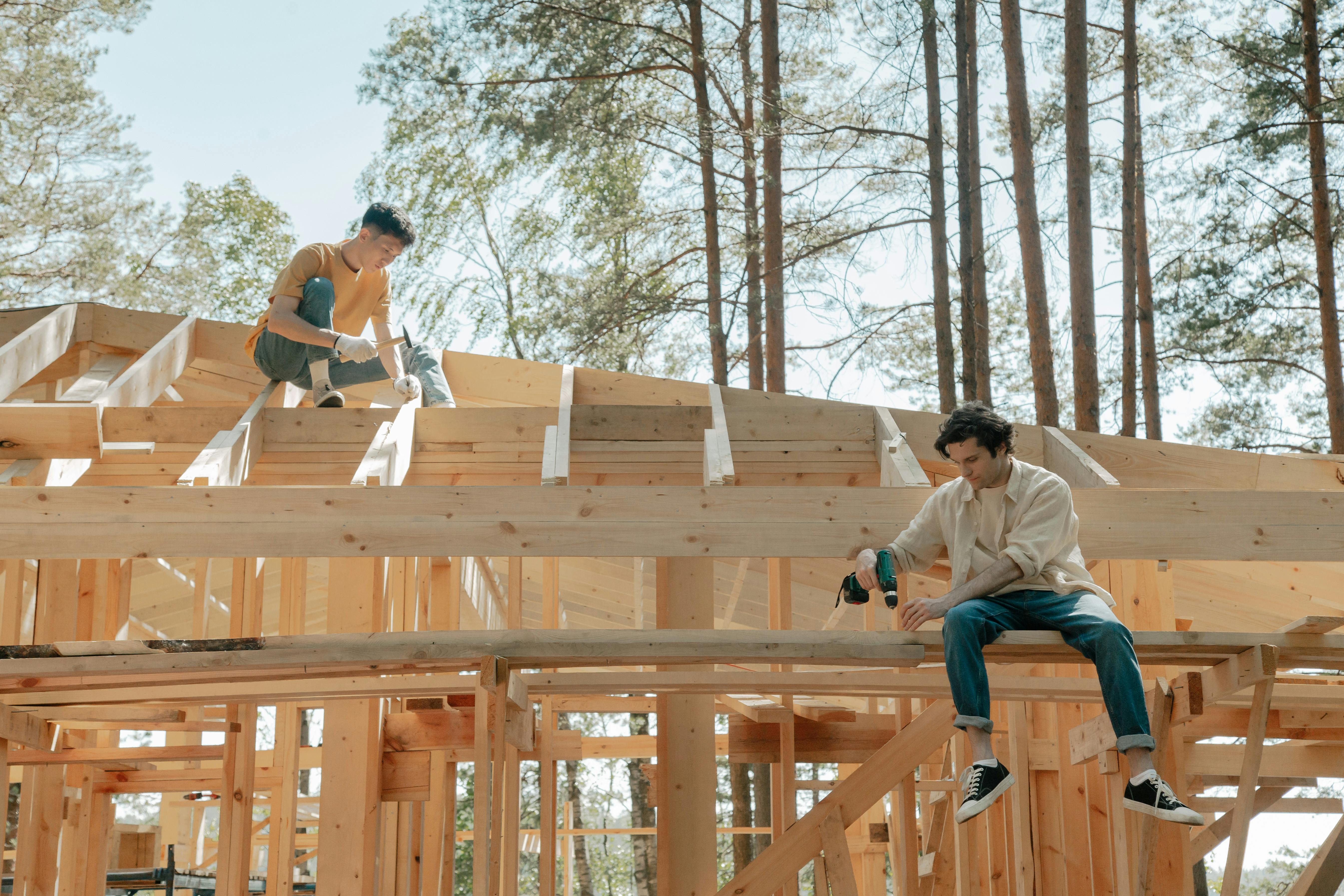 Construction carpenters working on timber framing and structural elements on a building site.