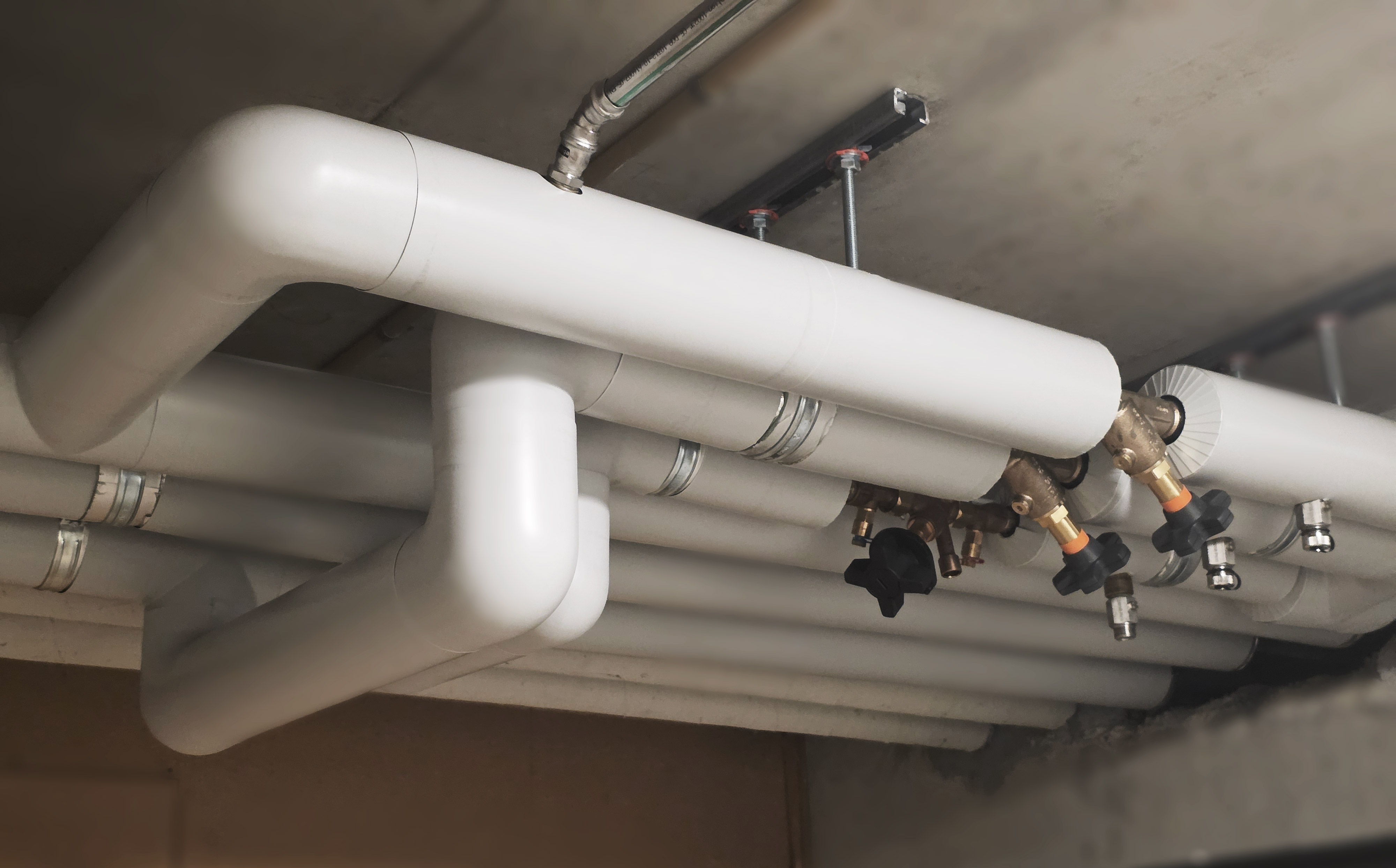 VVS pipe insulation system with Isover thermal insulation and Isogen outer layer, installed in a building service area.