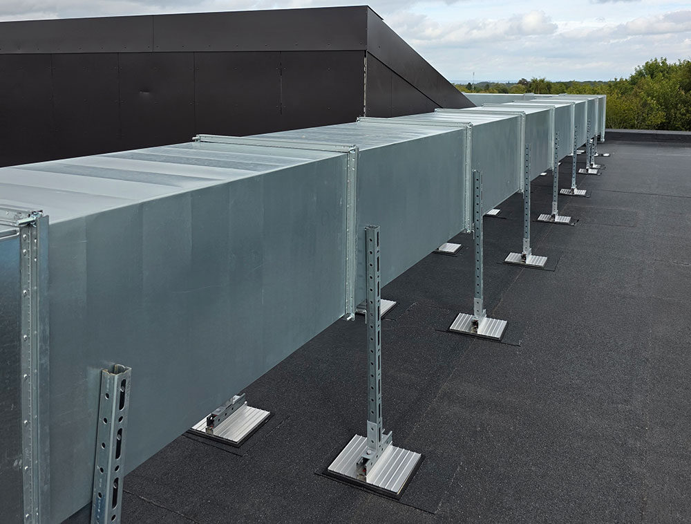 Outdoor ventilation duct installation on a flat roof, including supported HVAC duct systems.
