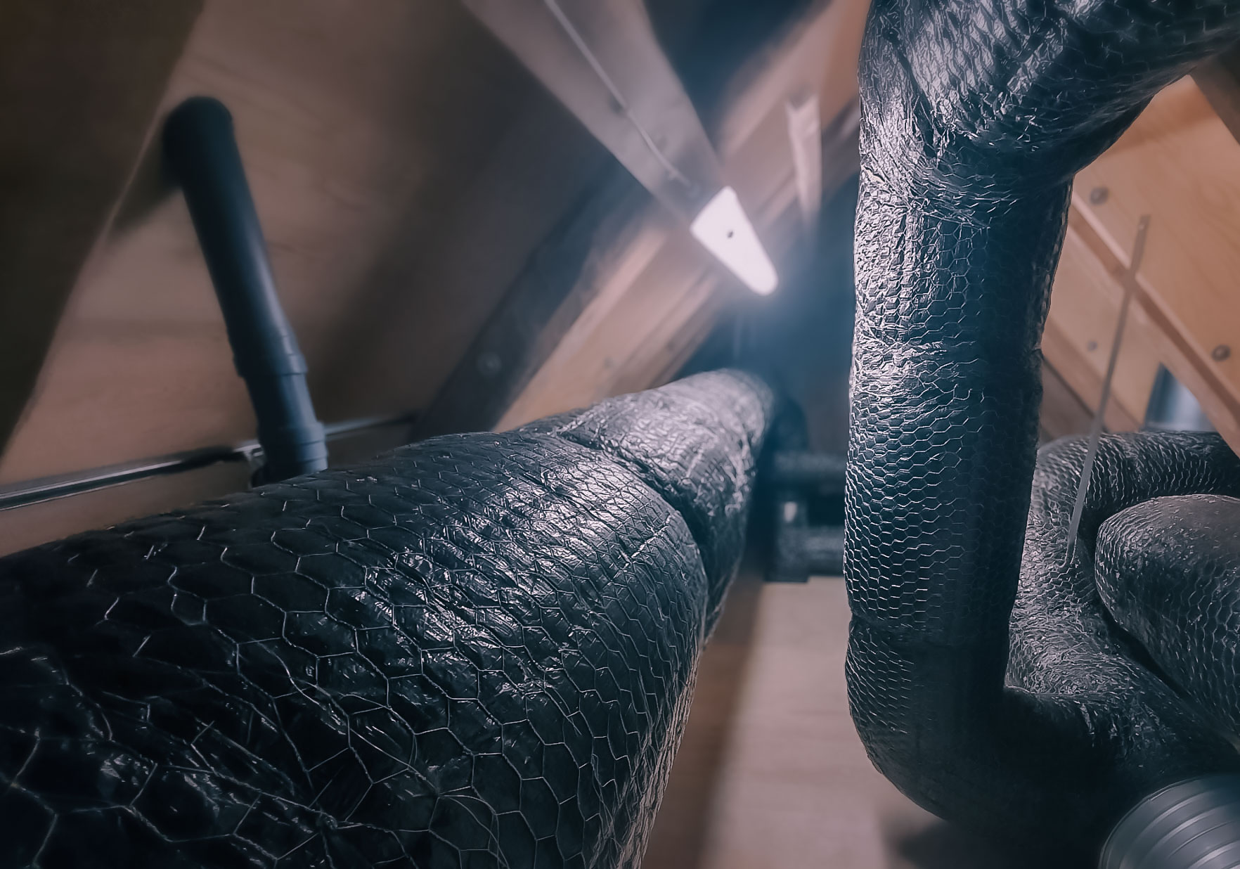 HVAC ductwork protected with wire mat fire insulation, showing detailed work around elbows and connections.